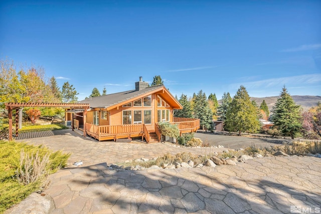 exterior space featuring a patio, a pergola, and a deck with mountain view