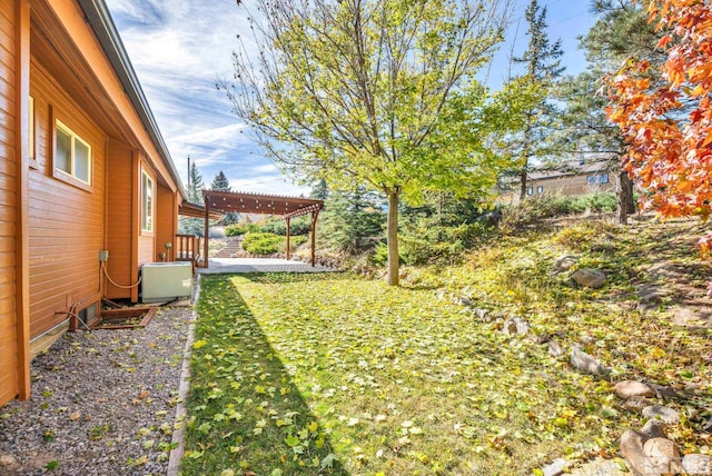 view of yard with a patio, central AC, and a pergola