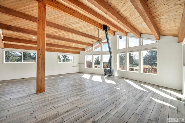 unfurnished sunroom featuring vaulted ceiling with beams, wood ceiling, a wood stove, and ceiling fan