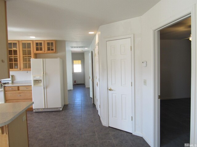 kitchen featuring white fridge with ice dispenser and dark tile patterned floors