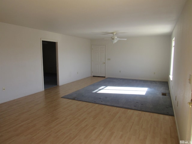 empty room with ceiling fan and light hardwood / wood-style floors