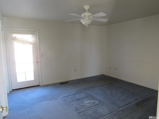 carpeted spare room featuring ceiling fan