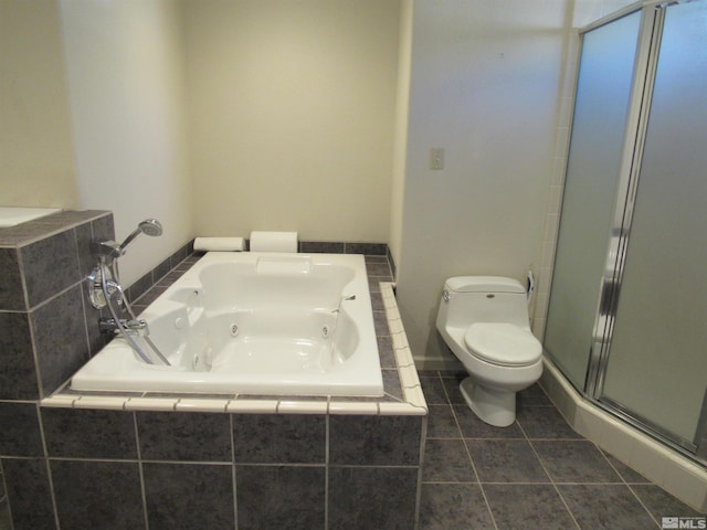 bathroom with toilet, tile patterned flooring, and tiled tub