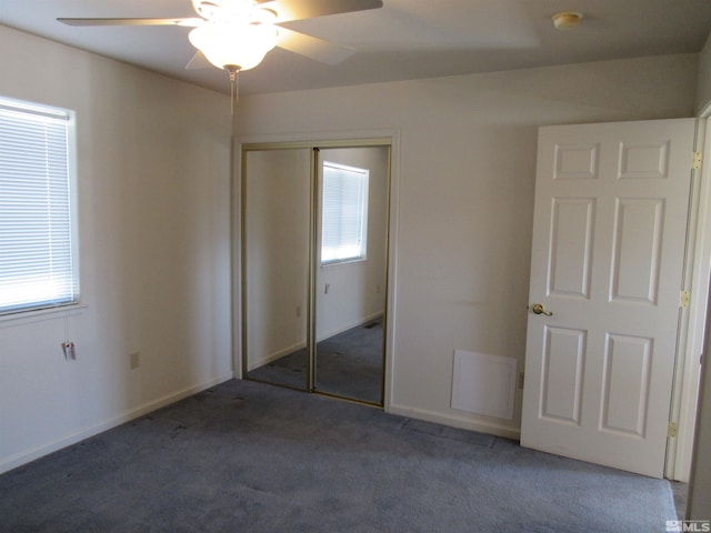 unfurnished bedroom featuring a closet, dark carpet, and ceiling fan