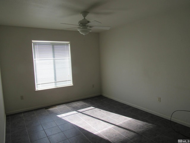 tiled empty room featuring ceiling fan