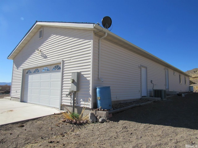 view of side of property featuring a garage and central AC