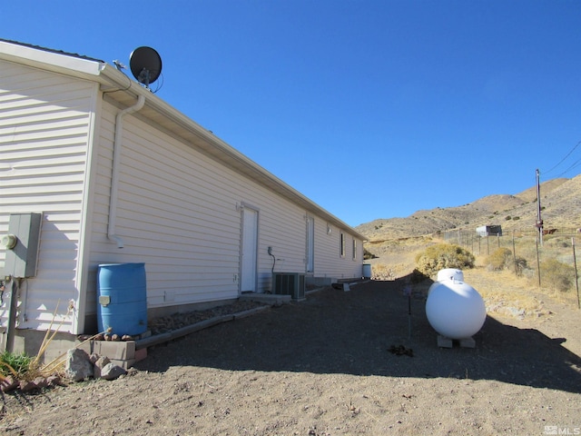 view of side of property featuring central AC unit and a mountain view