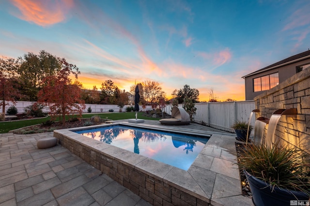 pool at dusk featuring a patio