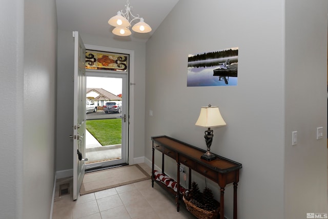 entrance foyer with a chandelier, plenty of natural light, lofted ceiling, and light tile patterned flooring