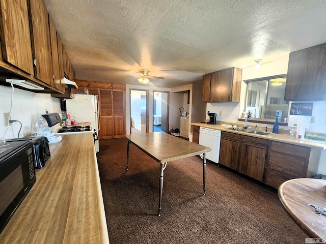 kitchen featuring white appliances, a sink, light countertops, a textured ceiling, and a ceiling fan