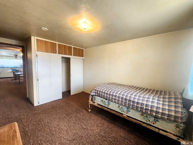 bedroom with dark carpet and a closet