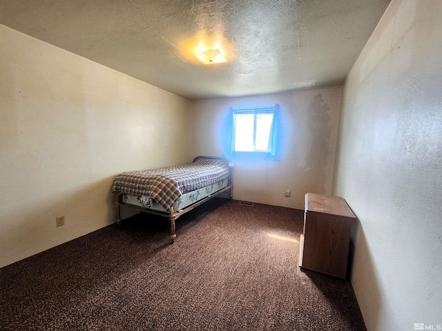bedroom with carpet floors and a textured ceiling