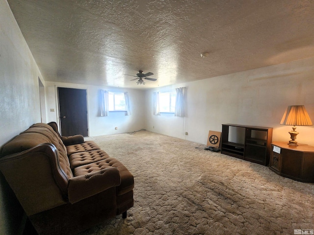 carpeted living room featuring ceiling fan and a textured ceiling