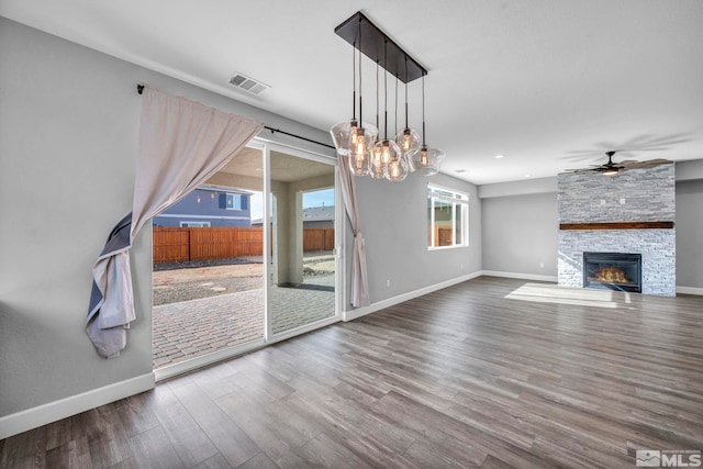 unfurnished living room featuring a fireplace, wood-type flooring, and ceiling fan