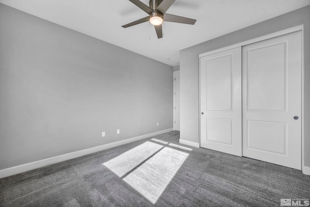 unfurnished bedroom featuring a closet, dark carpet, and ceiling fan