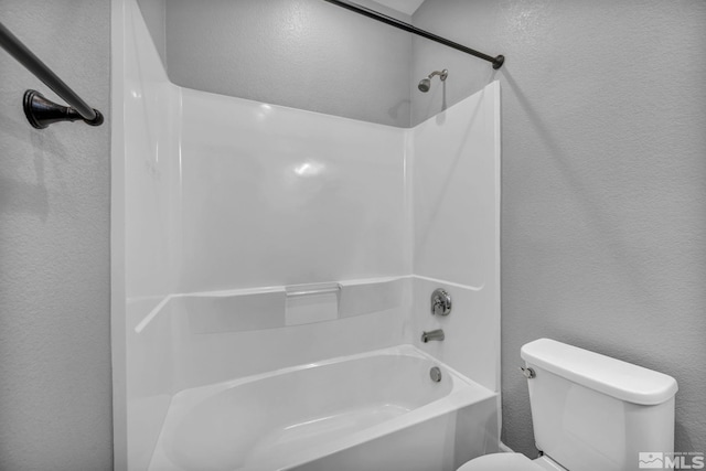 bathroom featuring washtub / shower combination and toilet