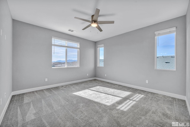 carpeted spare room featuring ceiling fan