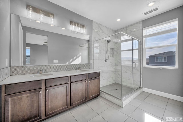 bathroom featuring tile patterned flooring, vanity, and a shower with shower door