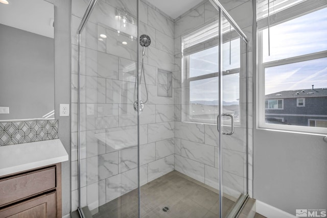 bathroom featuring a shower with door and a healthy amount of sunlight