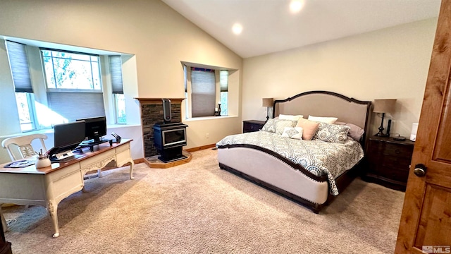 bedroom with a wood stove, carpet, and vaulted ceiling