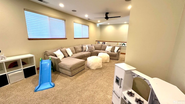 home theater with light colored carpet and ceiling fan