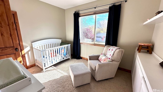 carpeted bedroom featuring a crib