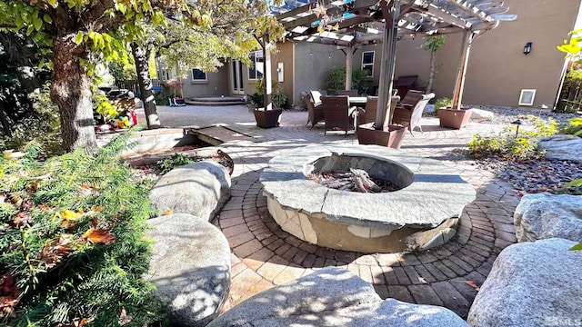 view of patio / terrace with a pergola and an outdoor fire pit