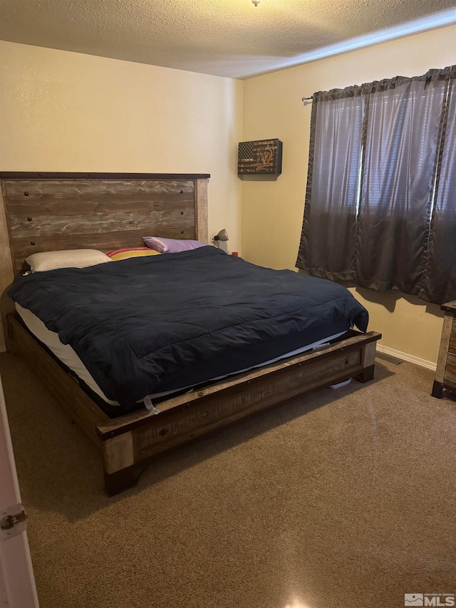 bedroom with carpet flooring and a textured ceiling