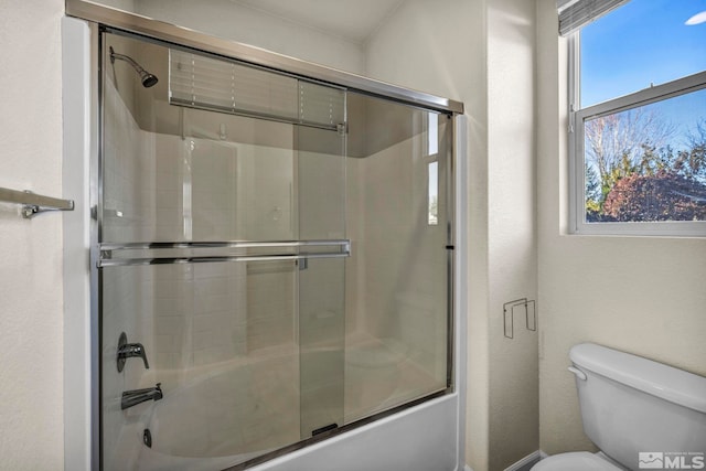 bathroom with enclosed tub / shower combo and toilet