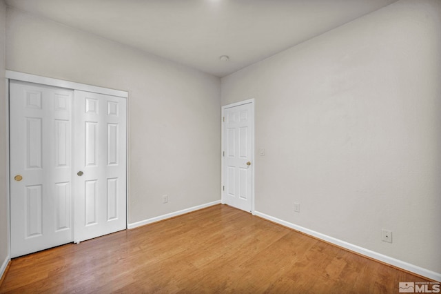 unfurnished bedroom featuring hardwood / wood-style flooring and a closet