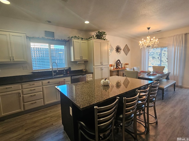 kitchen featuring a kitchen island, sink, dark hardwood / wood-style floors, and plenty of natural light