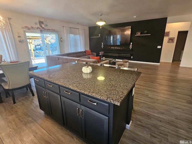 kitchen featuring dark wood-type flooring, stone countertops, and a kitchen island