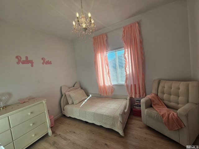 bedroom with light wood-type flooring and a notable chandelier