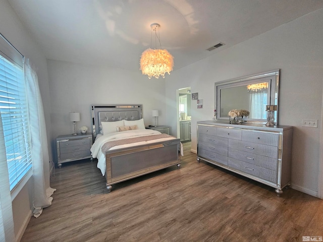 bedroom with dark hardwood / wood-style flooring and a notable chandelier