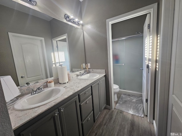 bathroom with walk in shower, wood-type flooring, toilet, and vanity