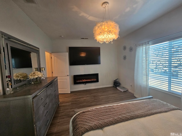 bedroom featuring dark hardwood / wood-style flooring and a notable chandelier