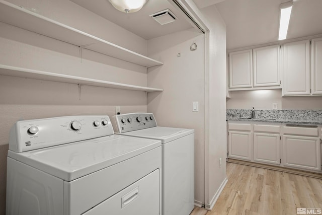 laundry room featuring washer and dryer and light hardwood / wood-style floors