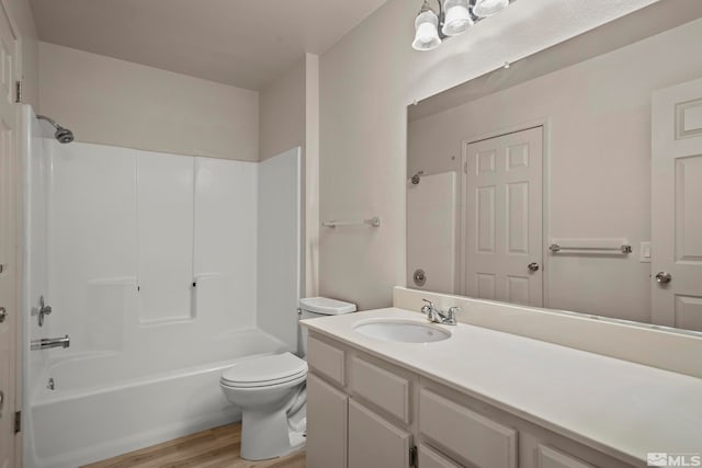 full bathroom featuring wood-type flooring, shower / tub combination, toilet, and vanity