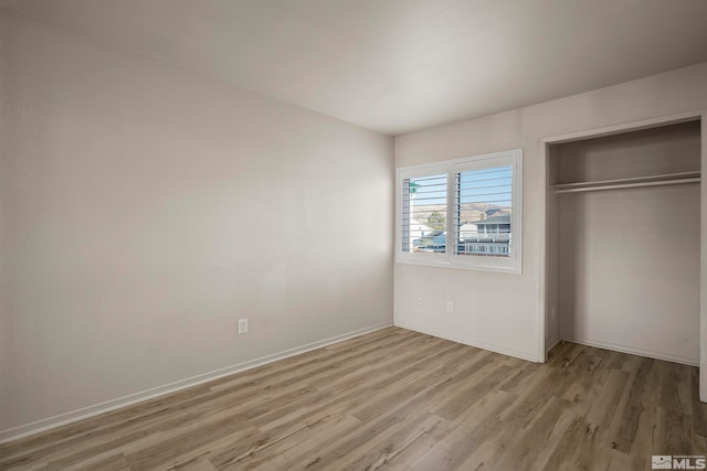 unfurnished bedroom with a closet and light hardwood / wood-style flooring