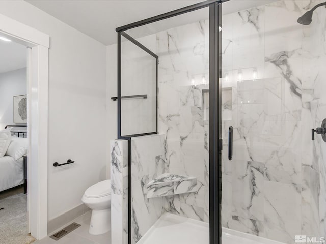 bathroom featuring toilet and an enclosed shower