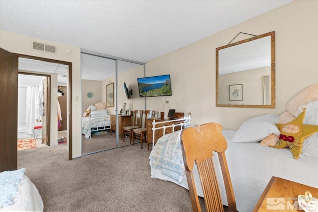 carpeted bedroom featuring a textured ceiling and a closet