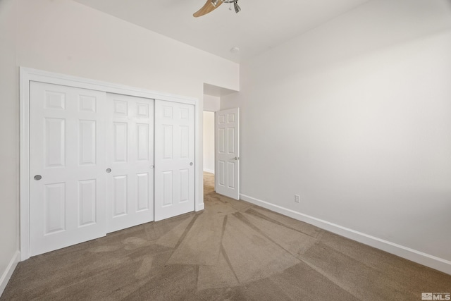 unfurnished bedroom with carpet floors, ceiling fan, and a closet