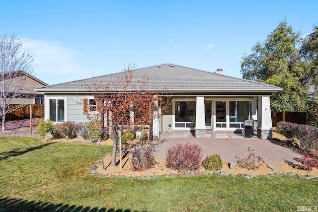 rear view of house with a yard and a patio area