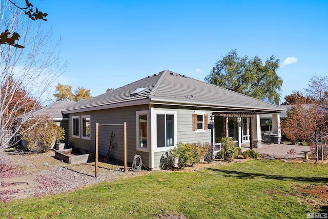 back of property with a lawn and a patio area