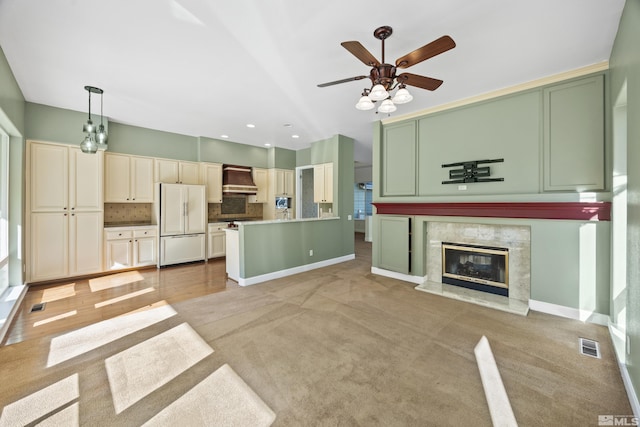 carpeted living room featuring a premium fireplace and ceiling fan