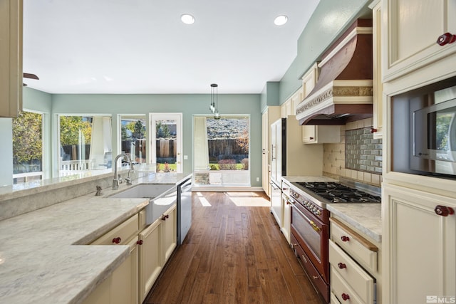 kitchen featuring dark wood-type flooring, cream cabinets, sink, and premium range hood