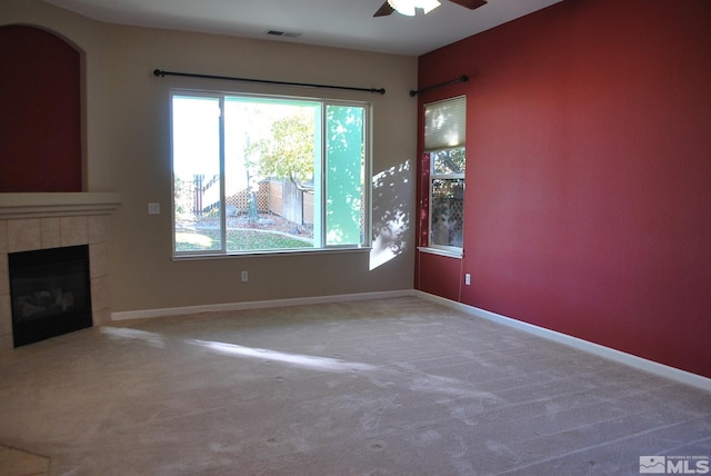 unfurnished living room featuring carpet, a fireplace, and ceiling fan