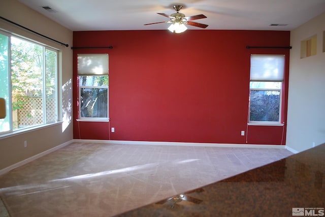 carpeted spare room with ceiling fan