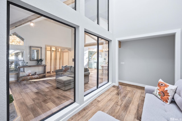 interior space featuring hardwood / wood-style flooring, beam ceiling, and high vaulted ceiling