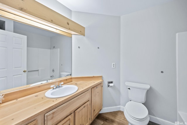 bathroom with toilet, vanity, and wood-type flooring